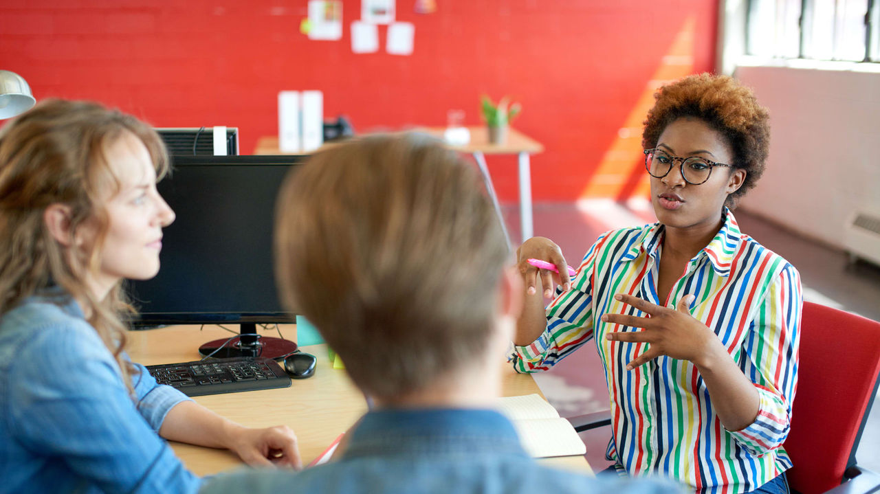 A group of people sitting around a table in an office.