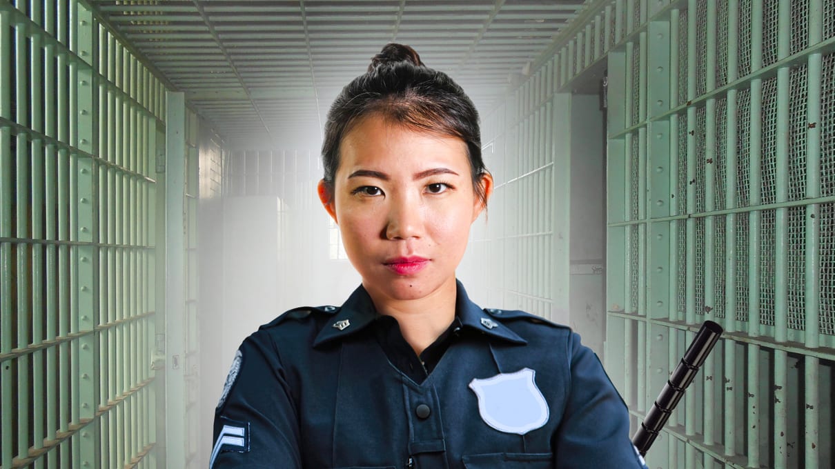 A police officer standing in a jail cell.