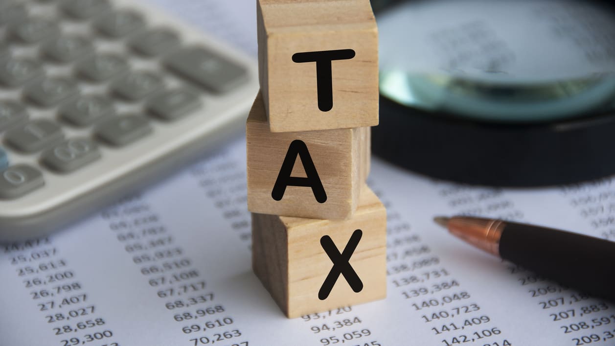 A stack of wooden blocks with the word tax on top.