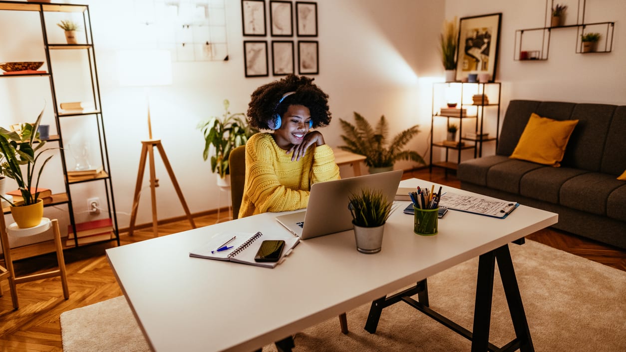 A woman working on her laptop in a living room.