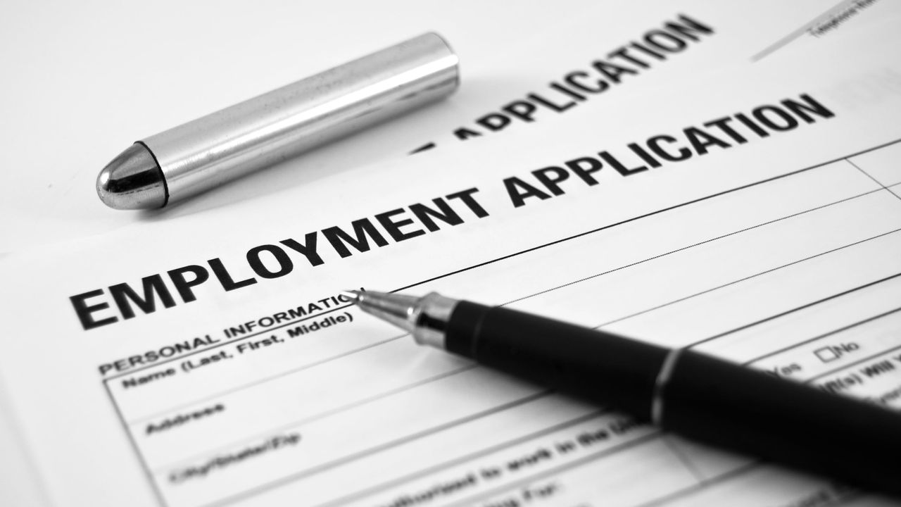 An employment application with a pen on top.