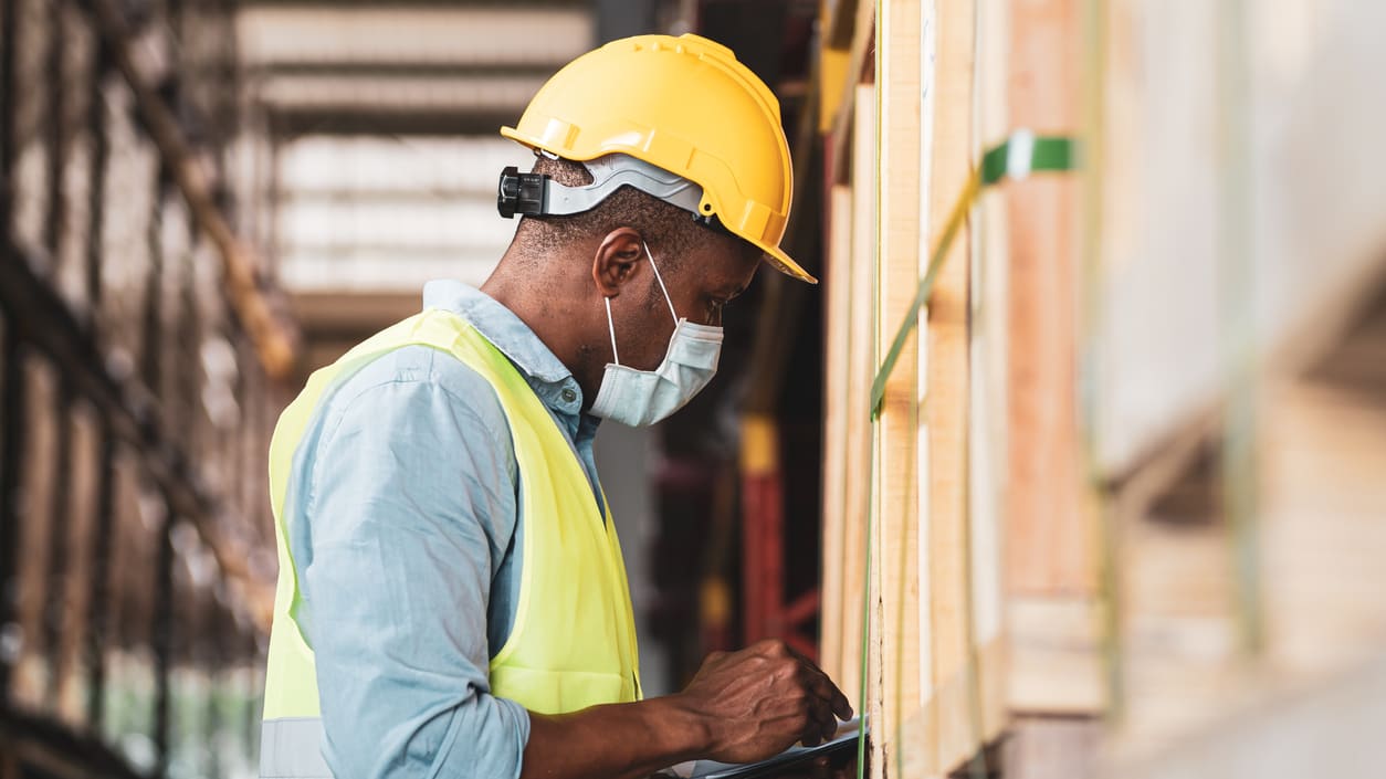A warehouse worker using a tablet in a warehouse.