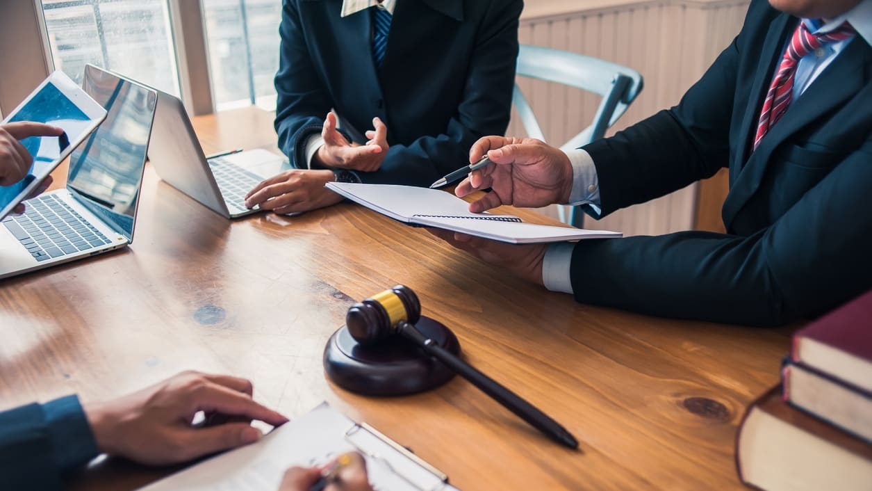 A group of business people sitting at a table with a gavel.