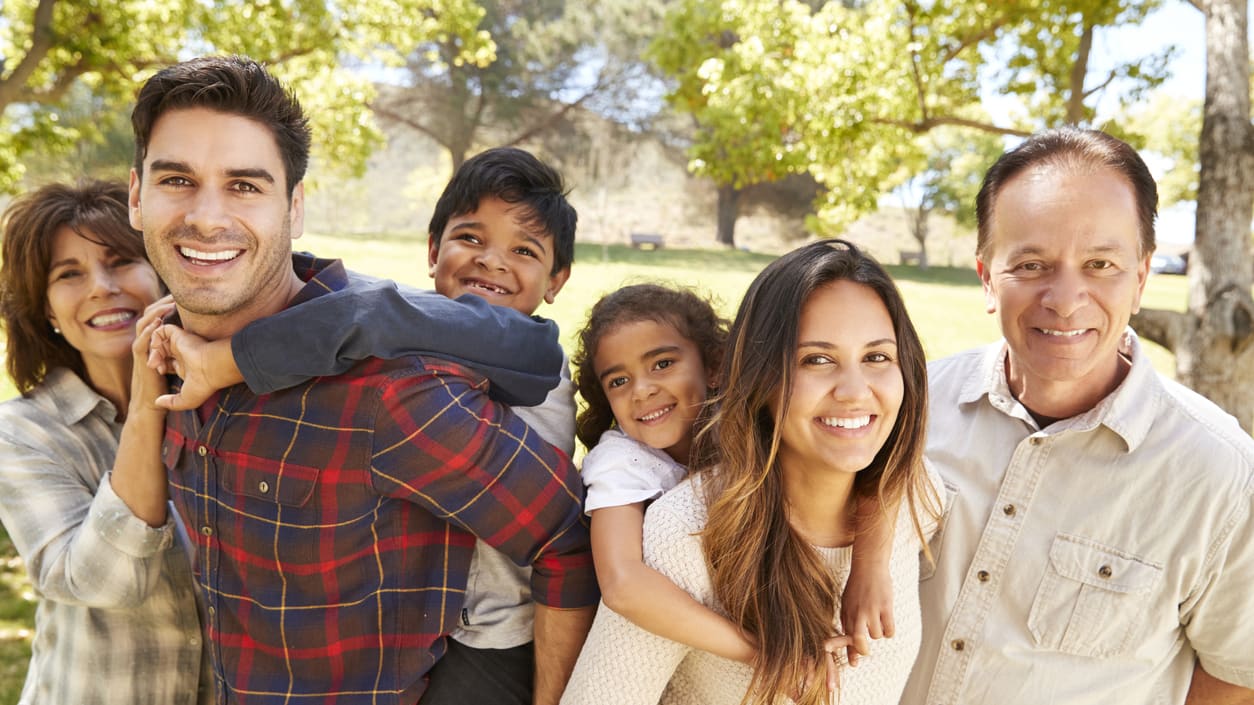 A family is posing for a picture in a park.