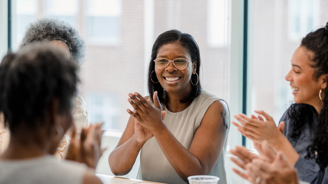 A group of people clapping at a meeting.