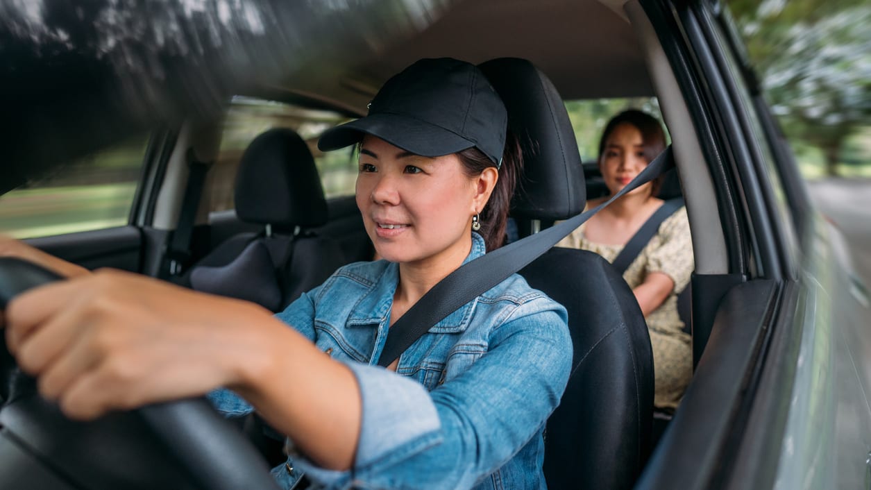 Two asian women driving a car.
