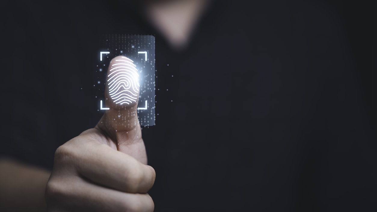 A man is pointing at a fingerprint on a credit card.