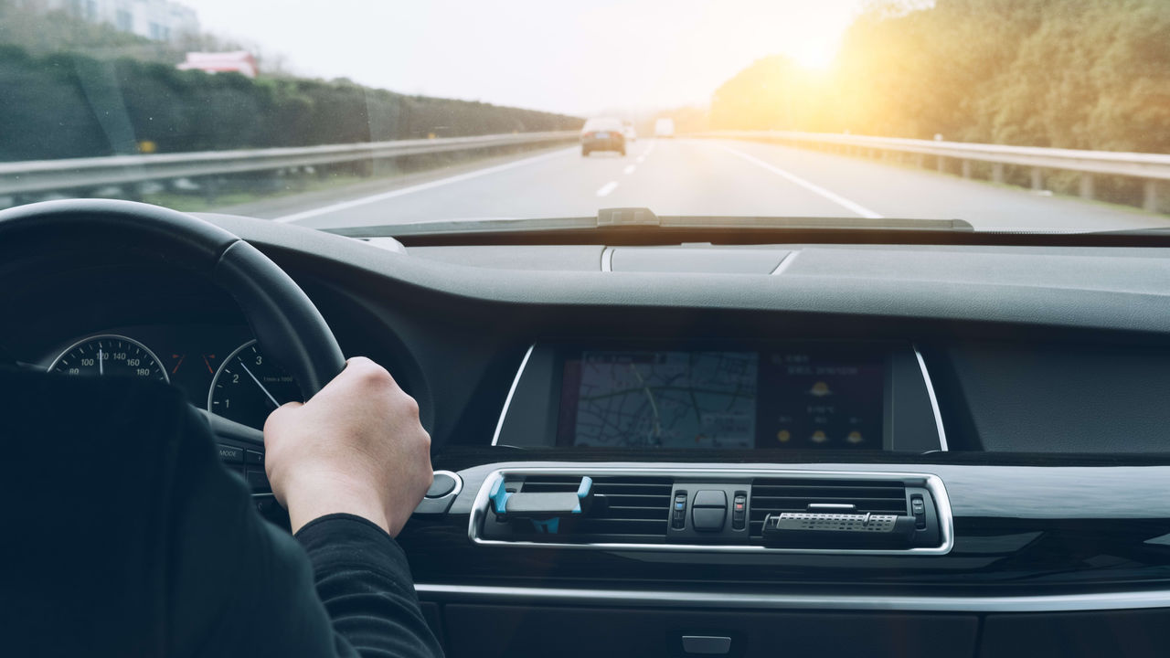A man driving a car on a highway.