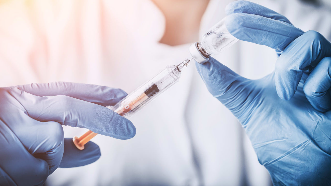 A doctor is holding a syringe in her hands.