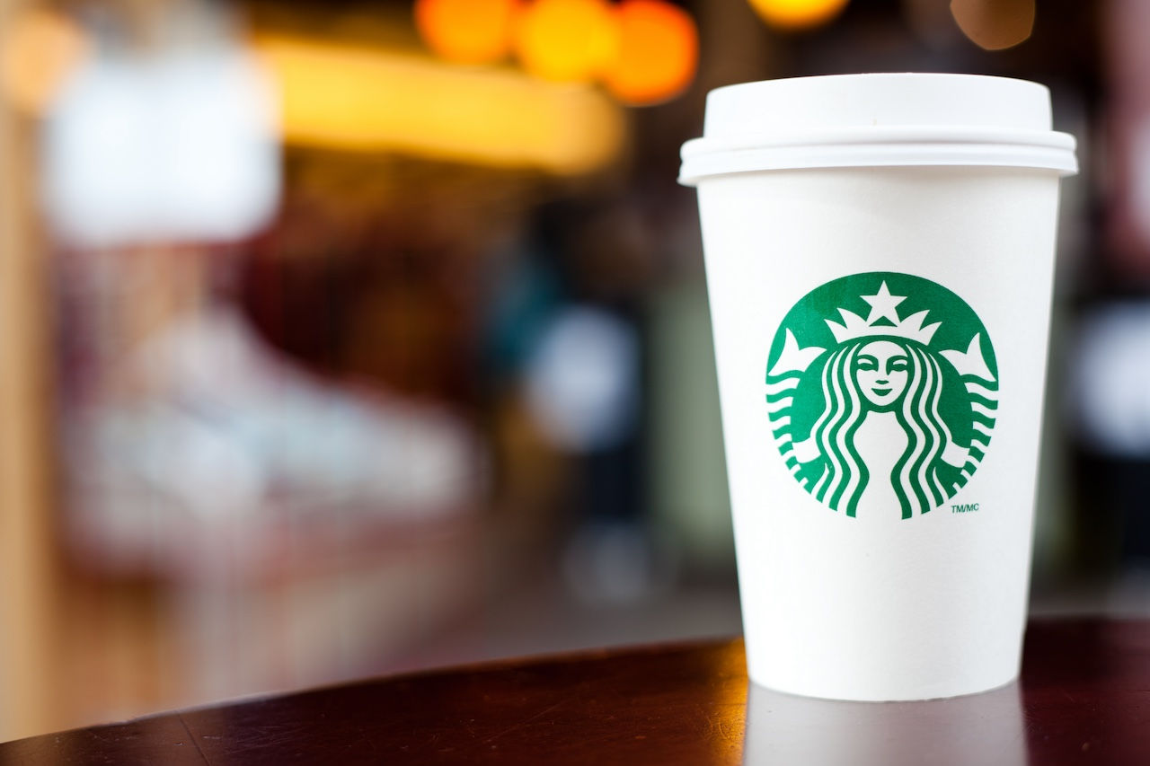 A Starbucks paper cup with the store logo on it