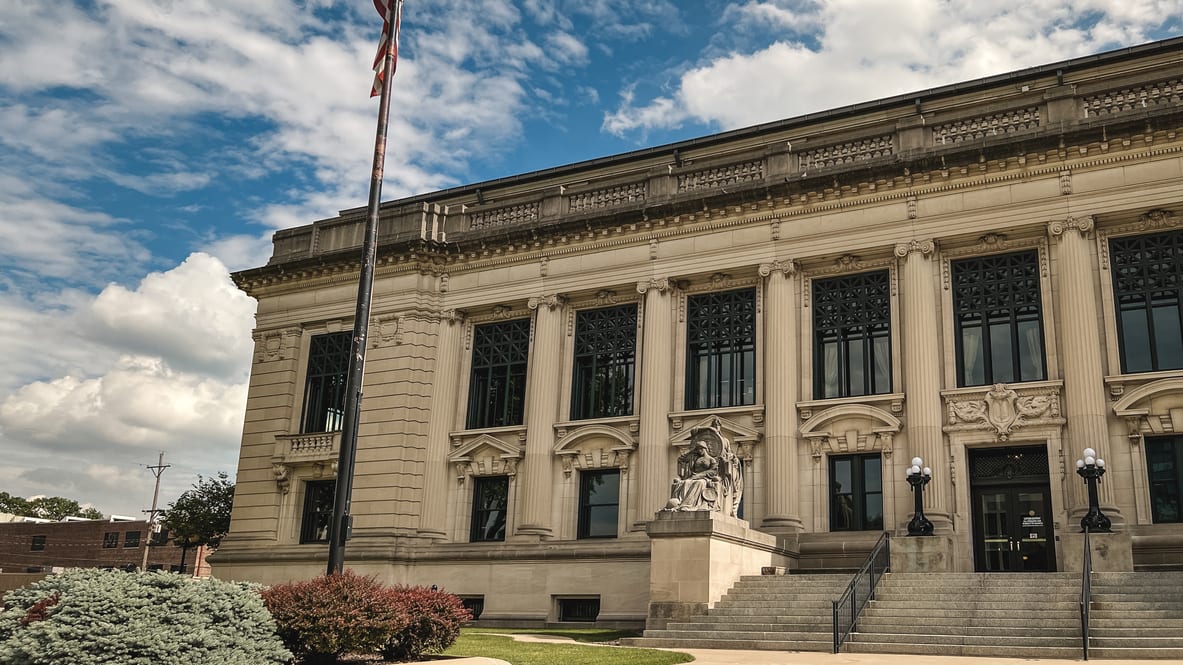 A large building with columns and a flag.