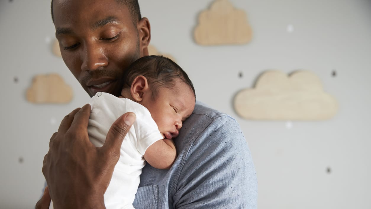 A man is holding a baby in his arms.