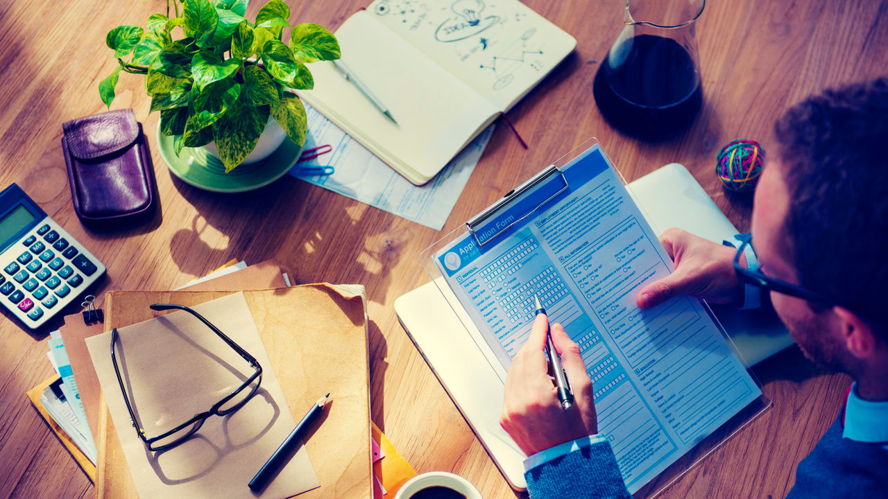 A man is sitting at a desk with a pen and paper.