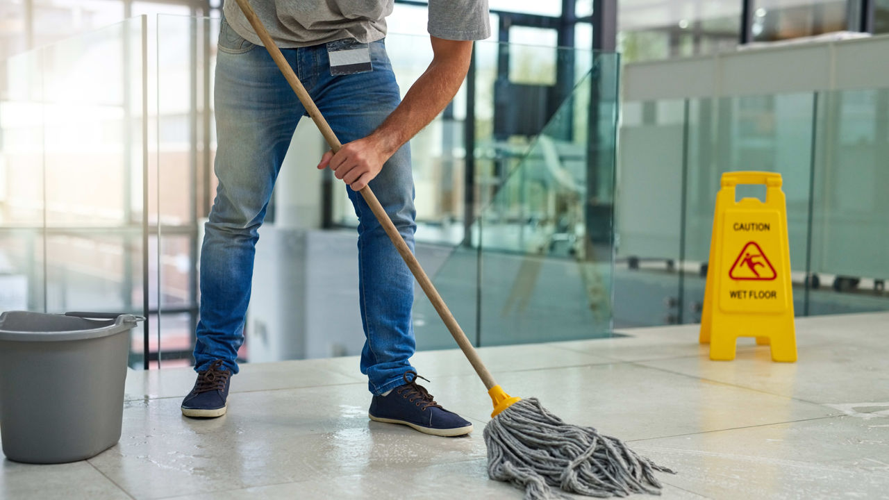 A man cleaning a floor with a mop.