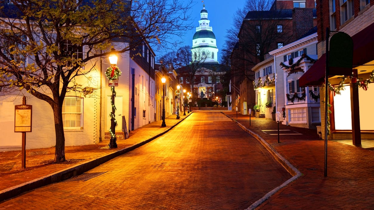 A brick street with a clock tower in the background.