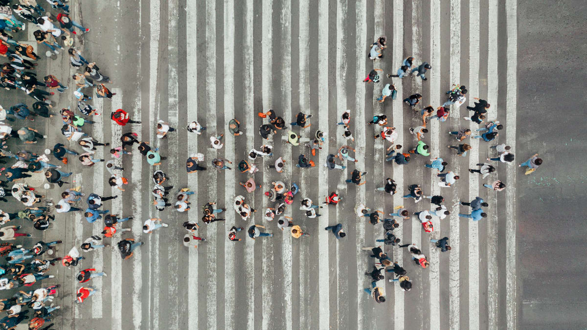 A large group of people crossing a street.