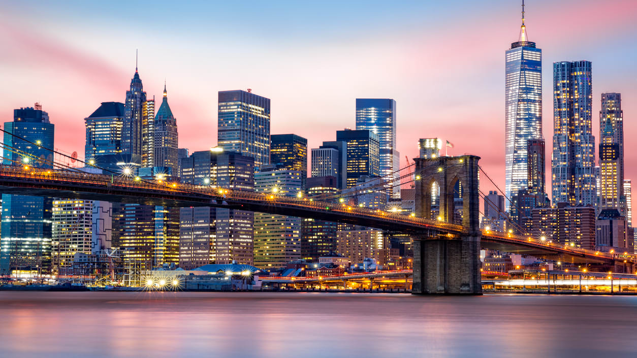 The brooklyn bridge and city skyline at sunset.