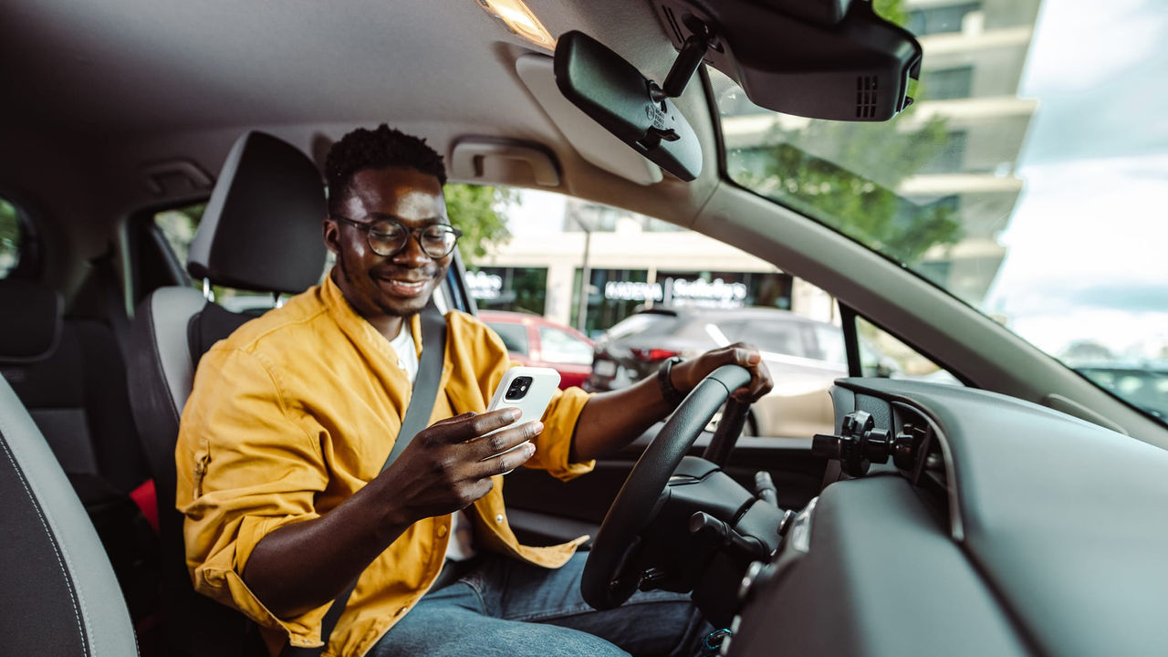 A man sitting in the driver's seat of a car.