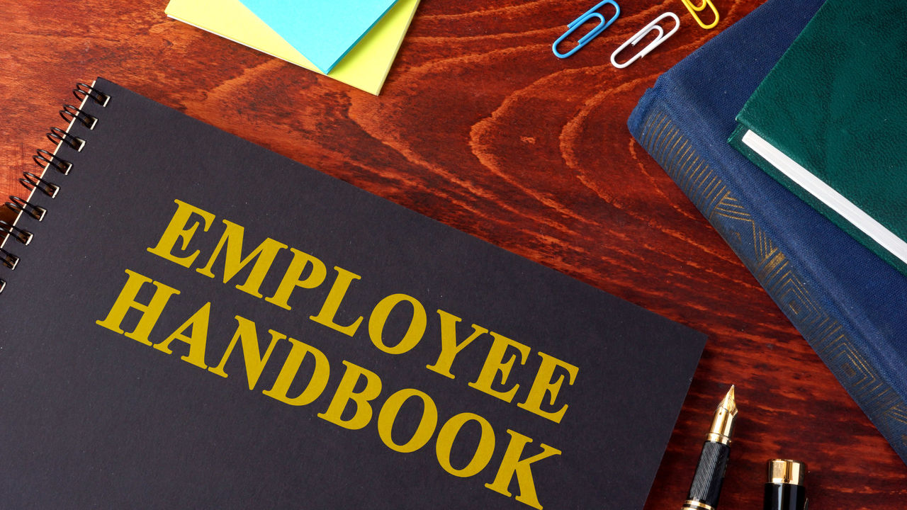 Employee handbook on a wooden table.