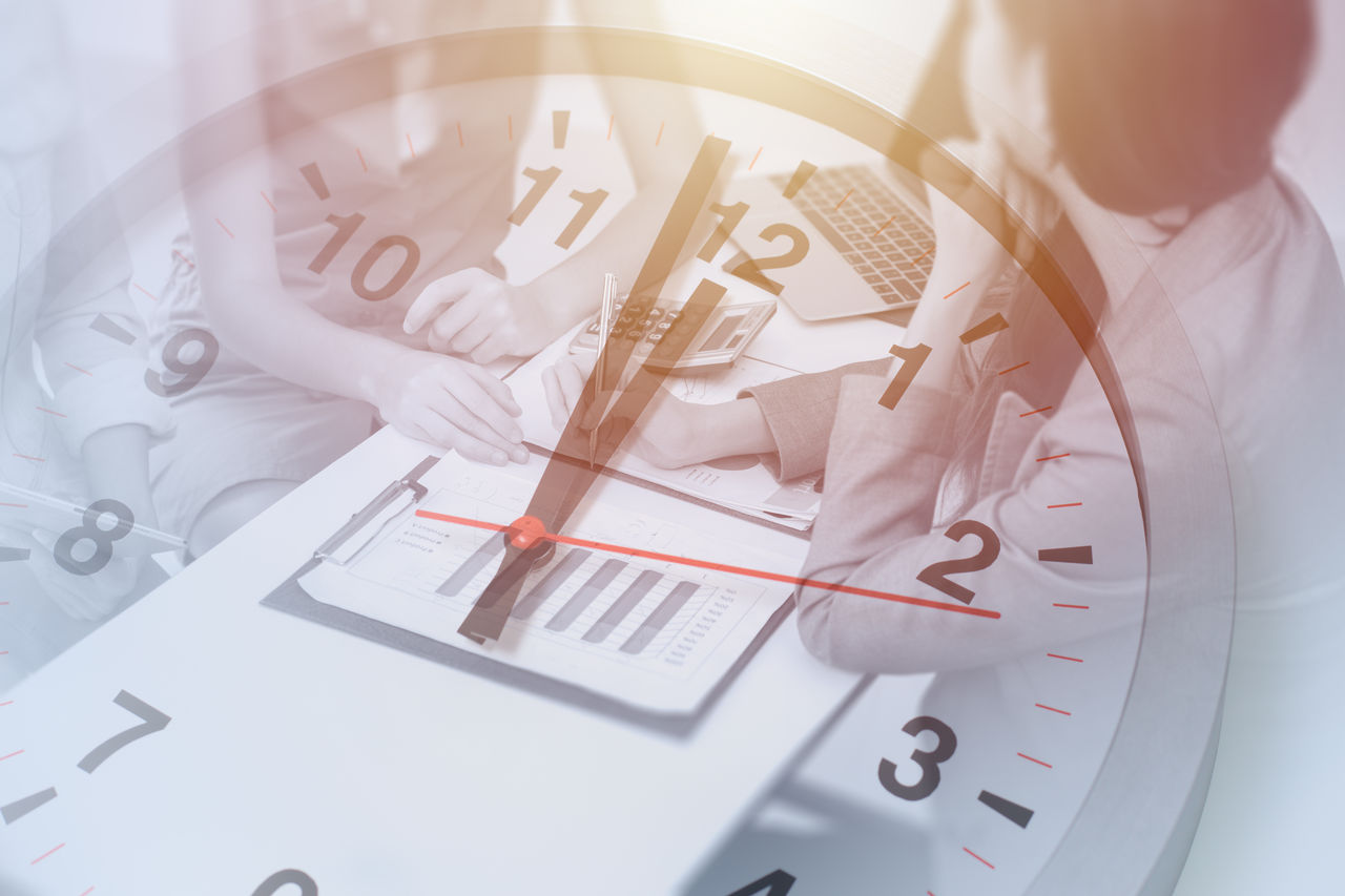 A clock superimposed over two workers