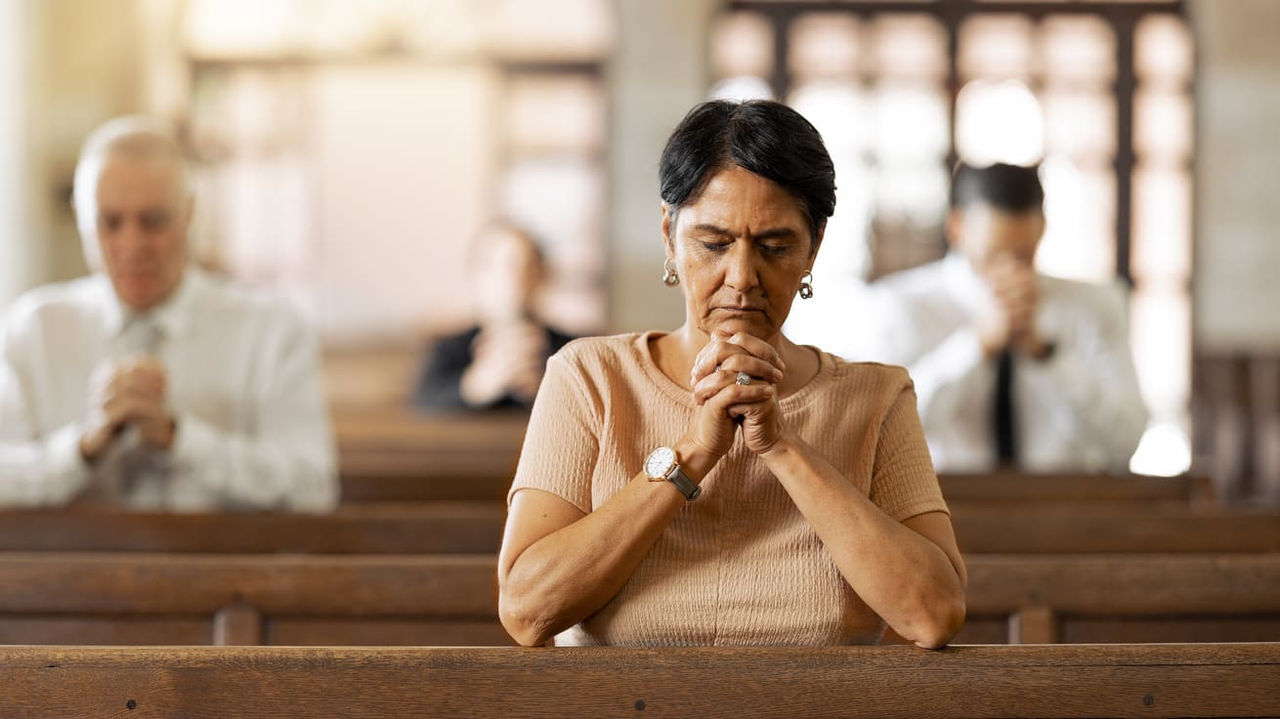 A woman praying in a church.