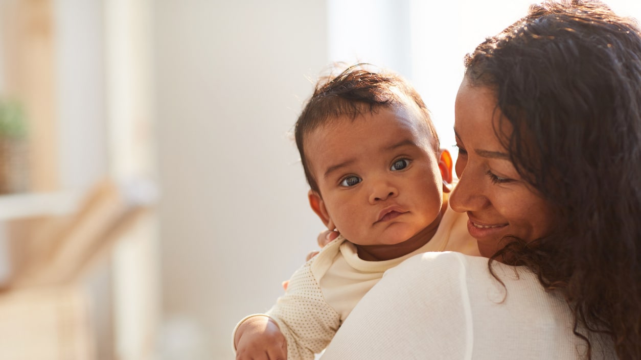 A woman is holding a baby in her arms.