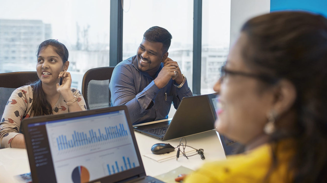 A group of people sitting around a table in an office.