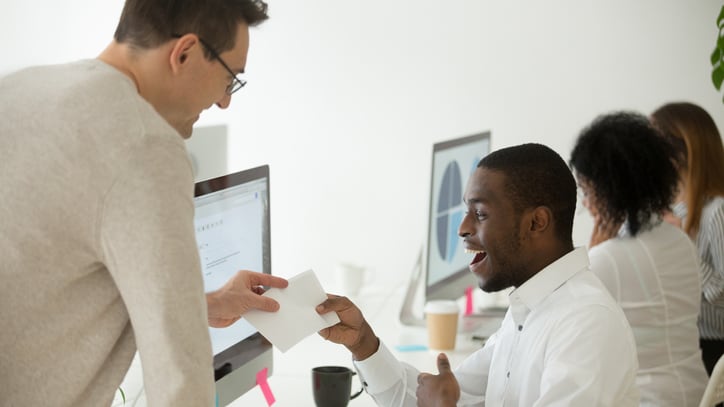 Two people in an office talking to each other.