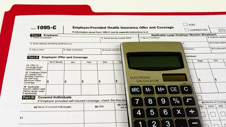 A calculator sits on top of a tax form.