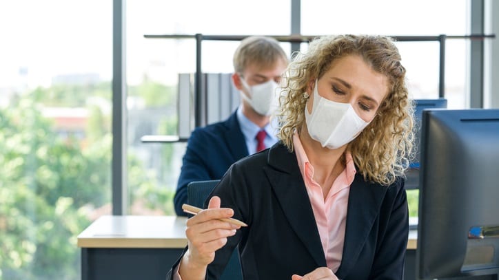 A woman wearing a face mask in the office.