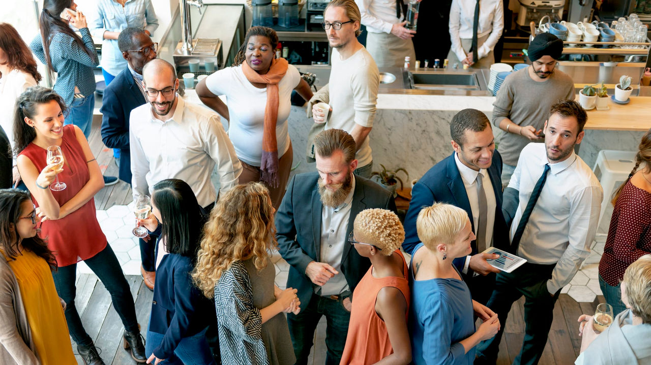 A group of people standing together in a coffee shop.