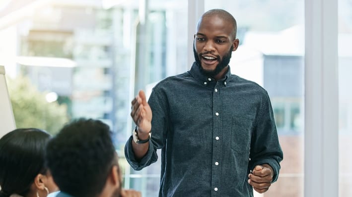 A man is giving a presentation to a group of people in an office.