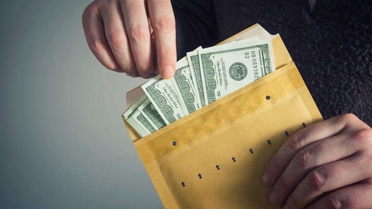 A man is holding money in an envelope.
