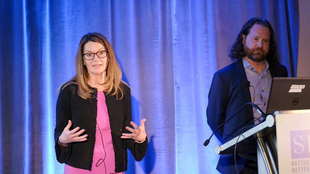 Two people standing in front of a podium.