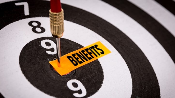 A dart hitting the center of a target with the word benefits on it.