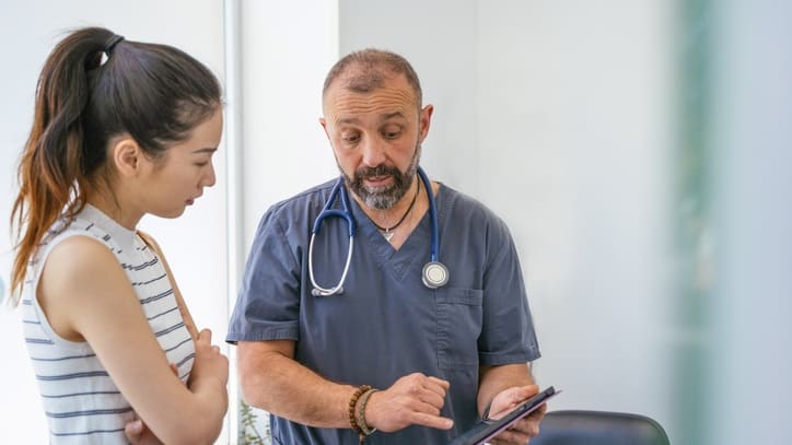 A doctor is talking to a patient in a doctor's office.