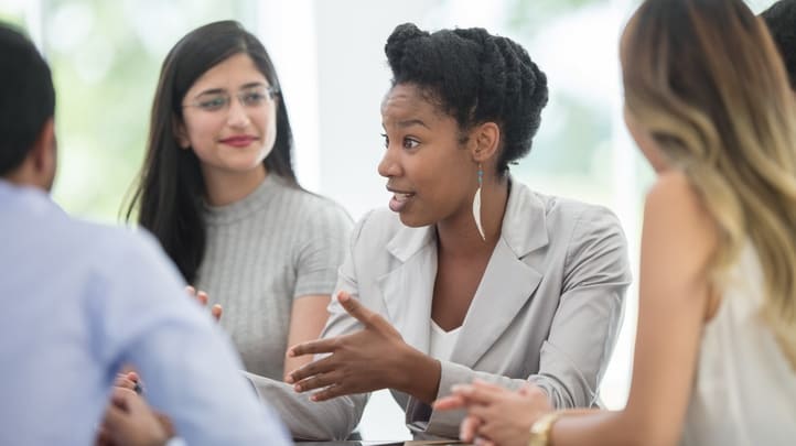 A group of business people talking at a meeting.