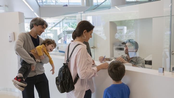 A group of people standing at a counter at a bank.