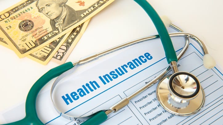 A stethoscope sits on top of a health insurance form.