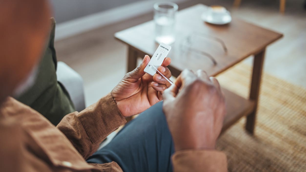 A man sitting on a couch holding a phone.