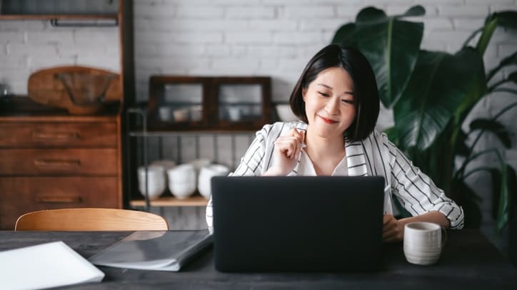 A young woman working on her laptop at home.