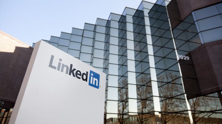 A linkedin sign is seen in front of a building.