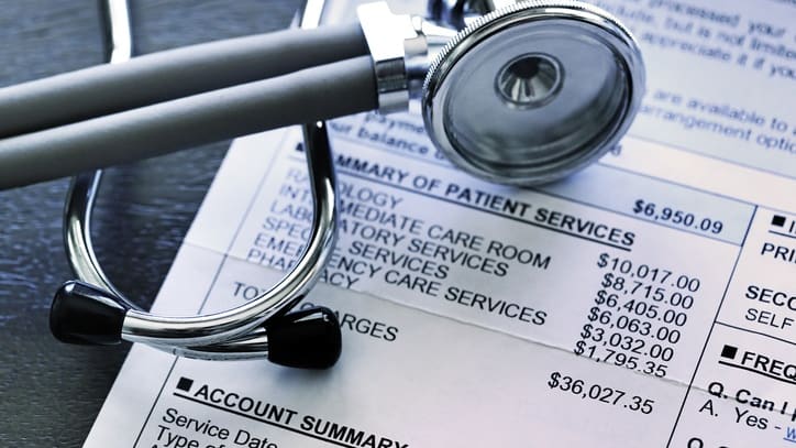 A stethoscope on top of a medical bill.