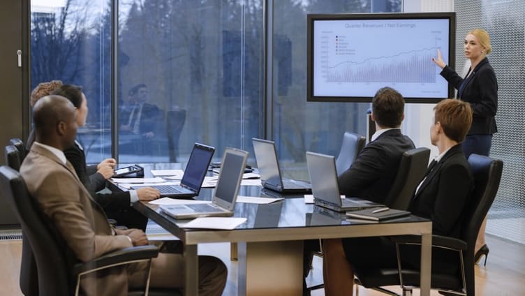 A group of business people giving a presentation in a conference room.