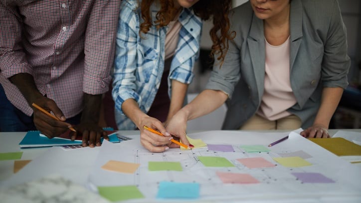 A group of people working on a piece of paper.