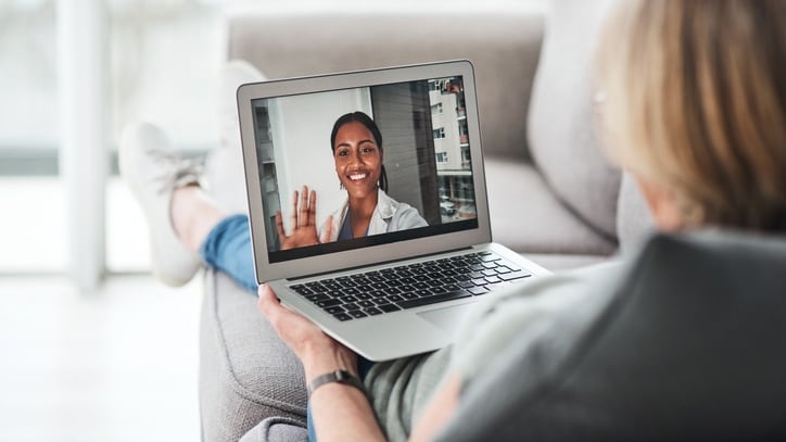 A woman is using a laptop to make a video call.