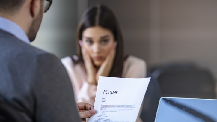 A man is looking at a woman's resume.