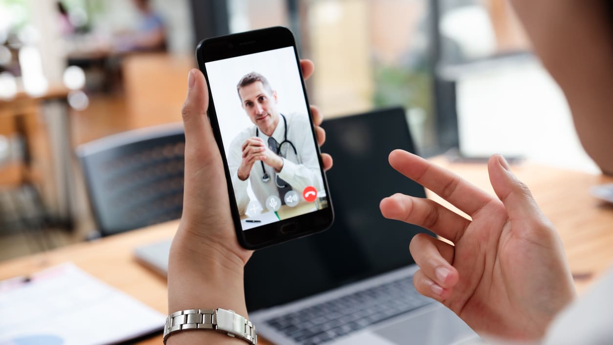 A woman is taking a picture of a doctor on her phone.