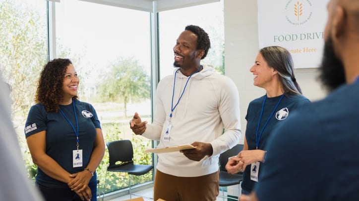 A group of people talking in an office.