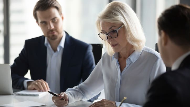 Three business people sitting at a meeting table.